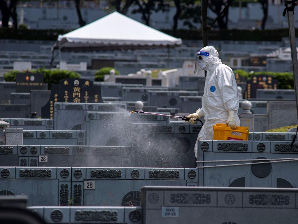 A man in protective suits disinfects a graveyard where Covid-19 victims are buried in Malaysia. Picture: Chong Voon Chung/Xinhua via Getty Images