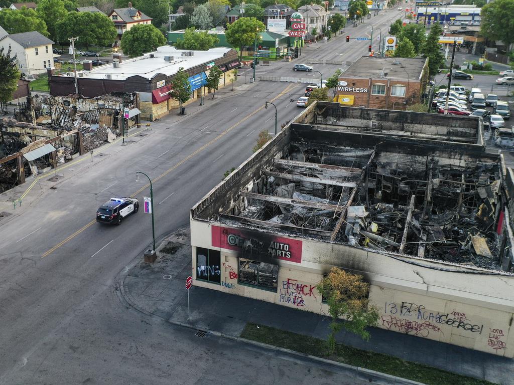 A police vehicle passes a building that was destroyed during protests two days prior in Minneapolis. Picture: John Minchillo