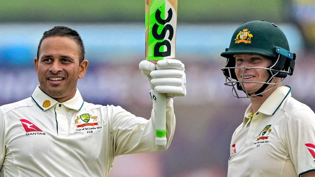 Australia's Usman Khawaja (L) celebrates with captain Steve Smith after scoring a century (100 runs) during the first day of the first Test cricket match between Sri Lanka and Australia at the Galle International Cricket Stadium in Galle on January 29, 2025. (Photo by Ishara S. KODIKARA / AFP)