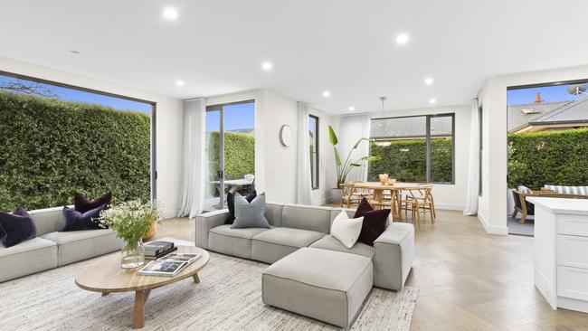 Herringbone engineered oak floors create a sophisticated natural palette in the open-plan living area.