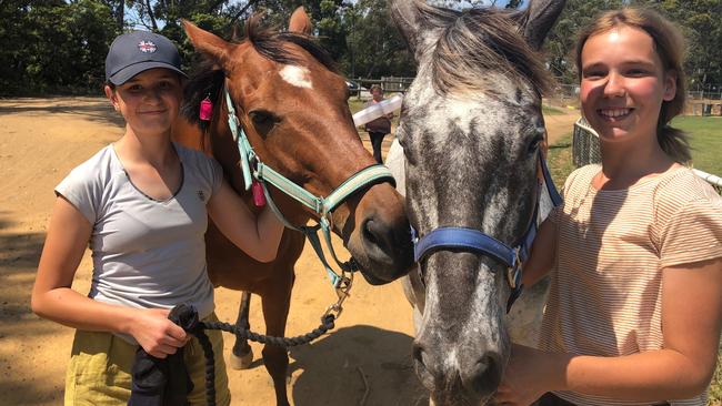 Ruby Cale (left), 14, of Ingleside with her horse Cash and Katie Schuitemaker, 12 of Belrose, with her horse Hugo, at Frenchs Forest Showground where they kept their horses during the fire emergency. Picture: Jim O'Rourke