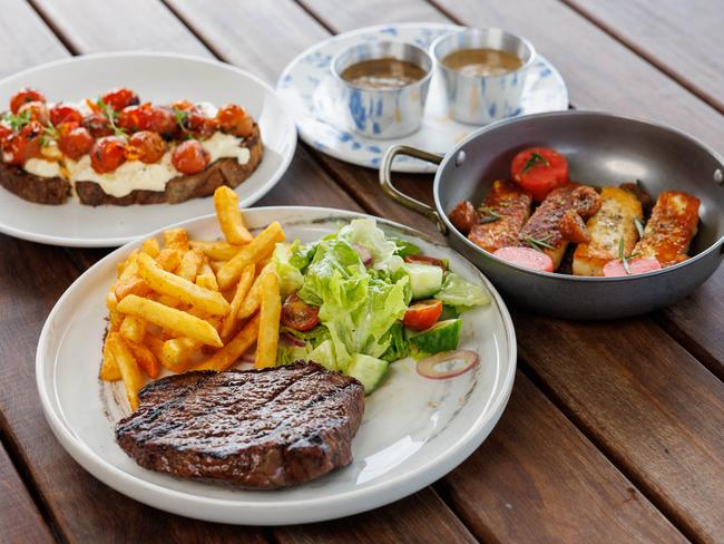 Bruschetta with vine tomato, stracciatella and basil, pan-seared Haloumi, compressed watermelon and figs, and a 250g Black Onyx rump, chips, salad and a sauce at The Locker Room in Sydney Olympic Park. Picture: Justin Lloyd