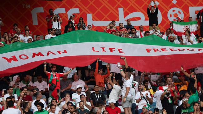 Iran supporters wave their national flag bearing the words ‘Woman, Life, Freedom’ as their team plays England in the World Cup in Qatar. Picture: AFP