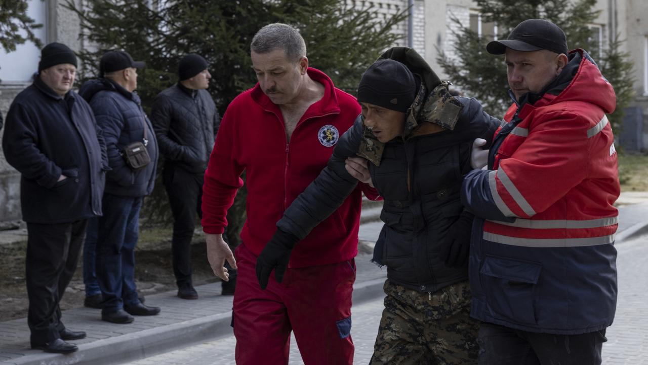 A man wounded in air strikes at a nearby military complex is assisted by medical staff outside Novoiavorivsk District Hospital on March 13, 2022 in Novoiavorivsk, Ukraine. Picture: Dan Kitwood/Getty Images