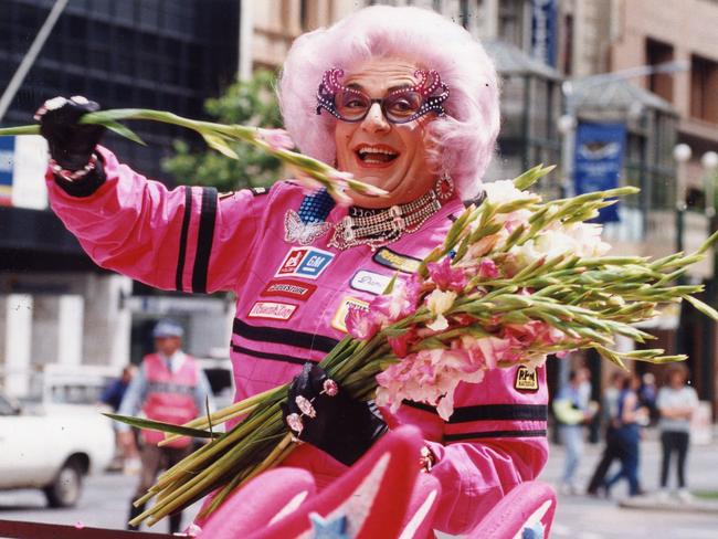 Comedian Barry Humphries as Dame Edna Everage during the Australian Grand Prix street parade down King William Street, Adelaide, 01 Nov 1993.  Pictured in her celebrity challenge car throwing gladioli flowers to the crowd.