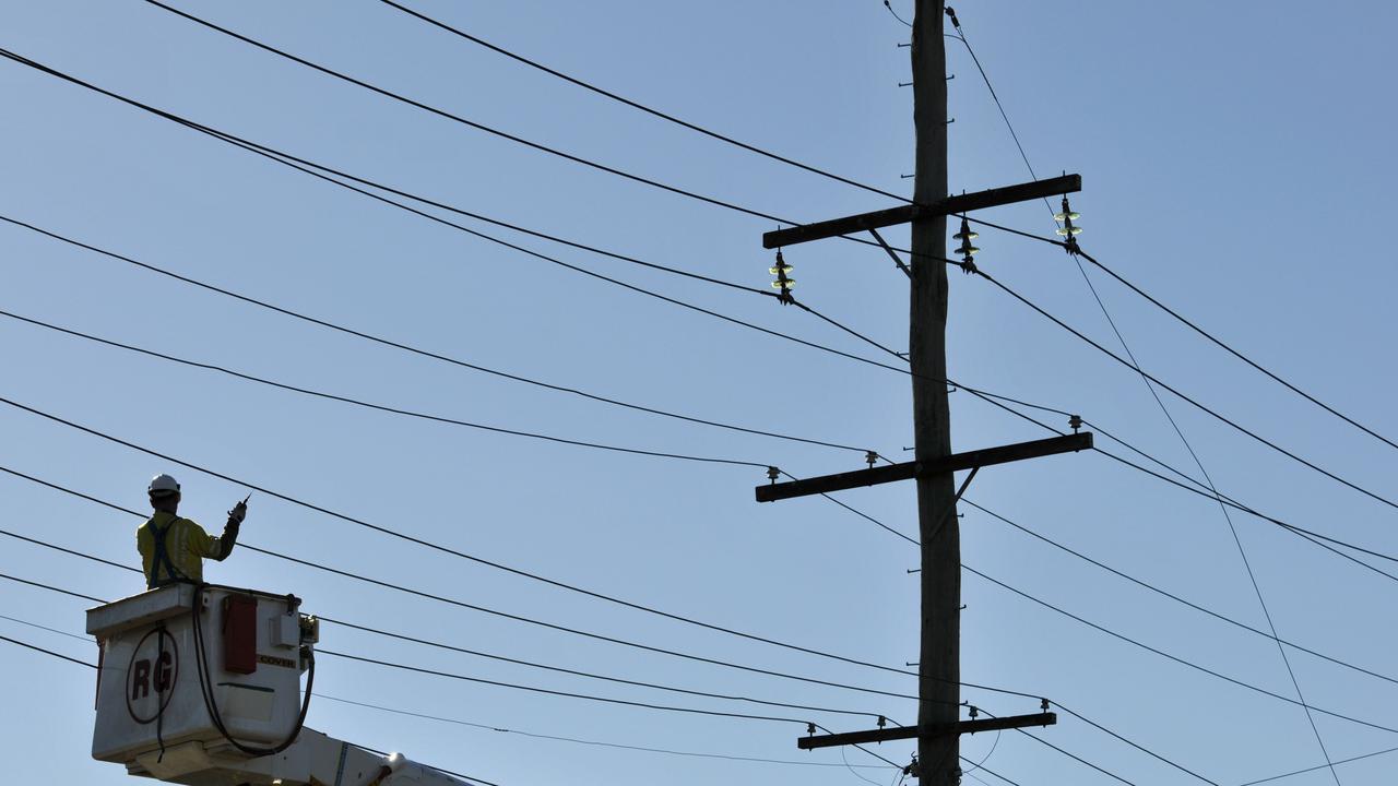 An Ergon worker inspects lines after a powerline was brought down. Generic file photo.