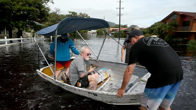 Jack Jennings with his cat Buffy being rescued in floodwaters in North Haven, near Port Macquarie. Picture: Nathan Edwards