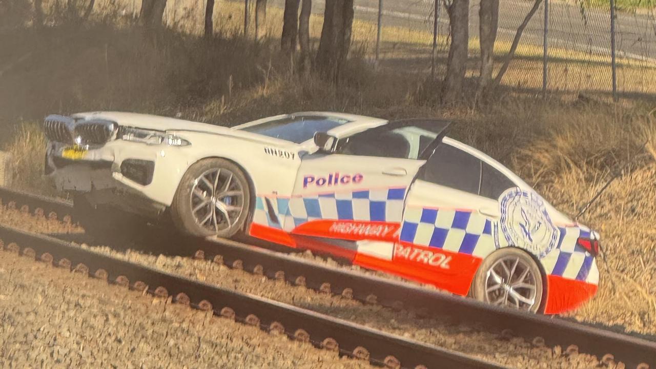 Wild moment before cop car lands on railway track