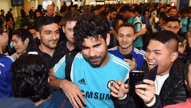 Chelsea football player Diego Costa (C) is mobbed by fans.