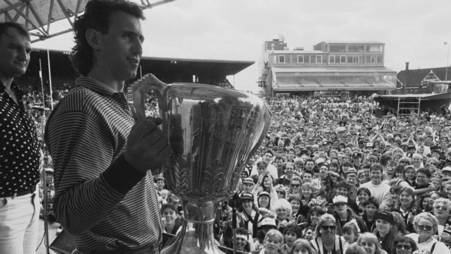 Peter Daicos presents the 1990 premiership cup to adoring Magpie fans at Victoria Park.