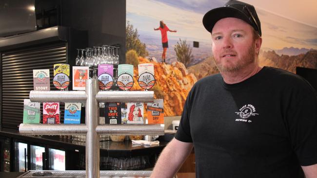 Alice Springs Brewing Co owner Kyle Pearson next to a selection of his beers at the namesake Alice Springs pub in August 2024. Picture: Gera Kazakov