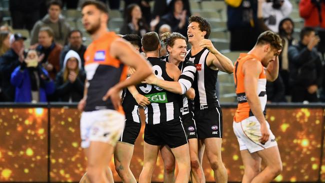 The Magpies celebrate victory as dejected Giants feel the pain. Pic: Getty Images