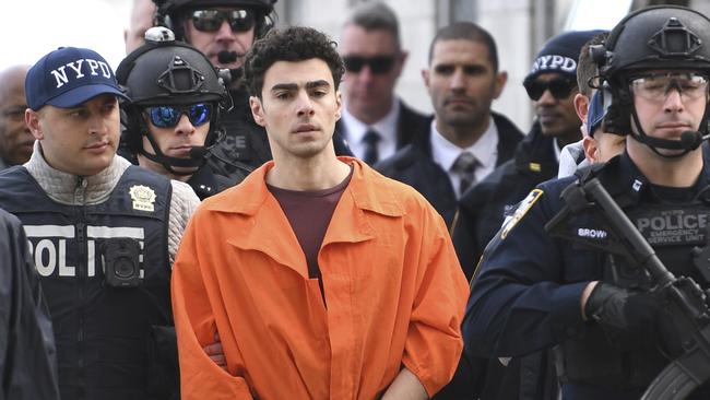 Luigi Mangione is escorted by police after landing in New York. Picture; AP.