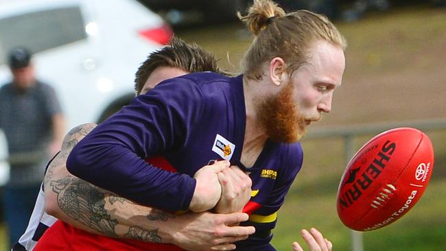 Diggers Rest’s Stephen Ruane tries to get a handball away against Macedon on Saturday. Photos: Carmelo Bazzano