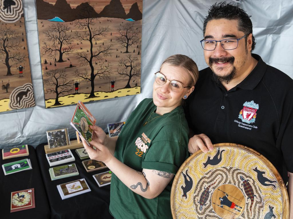 Ruth and Matt Yinn look over products by husband and wife duo Greg and Dee Locke (DG Murri Wood Art and Australian Indigenous Cards) at the Indigenous Artisan Markets at The Lighthouse, Saturday, December 17, 2022.