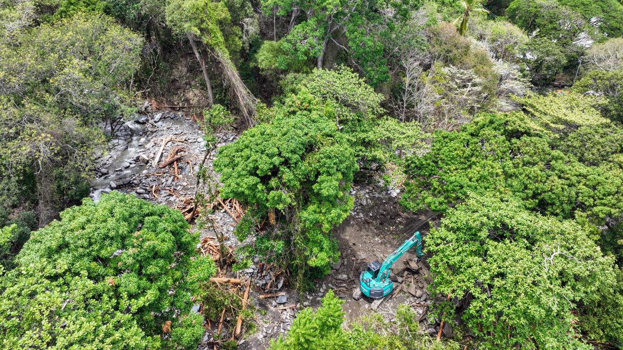 An excavator cleans debris from a huge landslide at Ellis Beach, Cairns. The northern beaches suburb has been smashed by landslides caused by flooding rain after ex Tropical Cyclone Jasper crossed the Far North Queensland coast. Mud, trees and rocks have caused large landslides across the Captain Cook Highway, which will take weeks to clean up and reopen. Picture: Brendan Radke