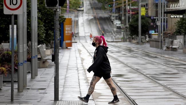 A woman crosses a deserted Bourke Street in Melbourne’s CBD on Tuesday. Picture: NCA NewsWire / David Geraghty