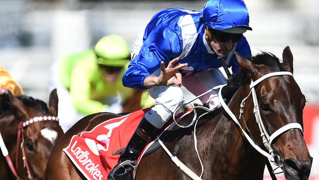 Hugh Bowman gives his familiar hand gesture has super mare Winx charges to victory in the Caulfield Stakes. Picture: AAP