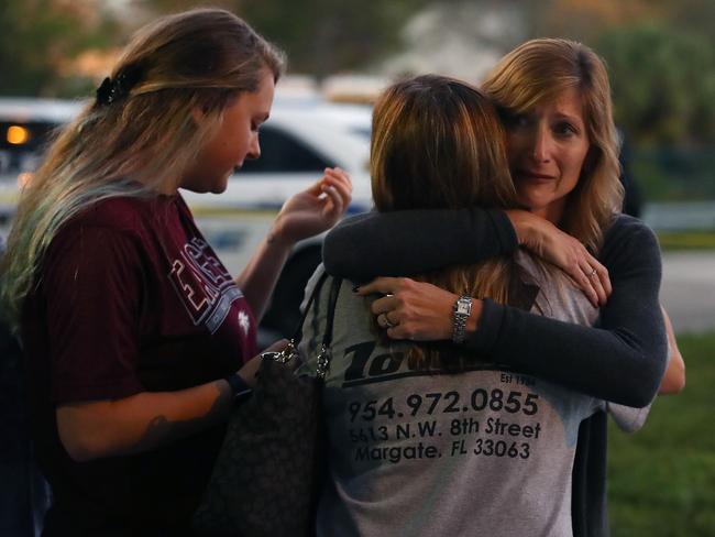 Kristi Gilroy (R), hugs a young woman at a police check point near the Marjory Stoneman Douglas High School where 17 people were killed. Picture: Getty