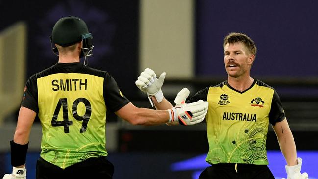 Australia's David Warner bump fists with teammate Steven Smith during the ICC men’s Twenty20 World Cup cricket match between Australia and Sri Lanka at the Dubai International Cricket Stadium in Dubai on October 28. Picture: AFP