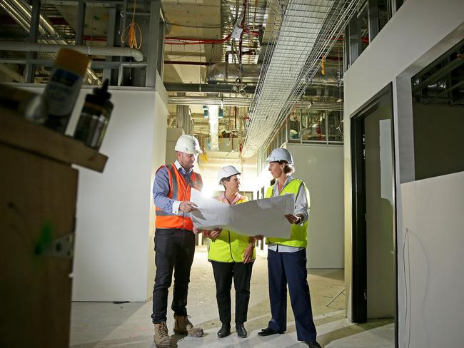 Project Manager Jason Ryan, Healthscope project director Deb Latta &amp; Manly Hospital Nursing Unit Manager Joanne Watts look over plans inside the Emergency Department at the Northern Beaches Hospital construction site at Frenchs Forest. Picture: Troy Snook