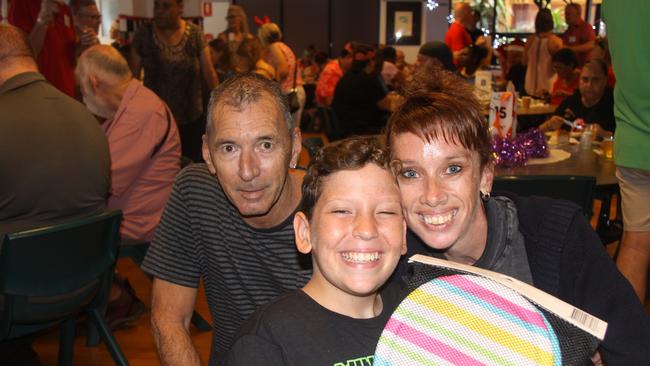 Happy to be at the 2022 Cairns Community Christmas Lunch were Harry Jewson with partner Yvette Santiago, her son Lucas, 12, who was thrilled with his present. Picture: Alison Paterson