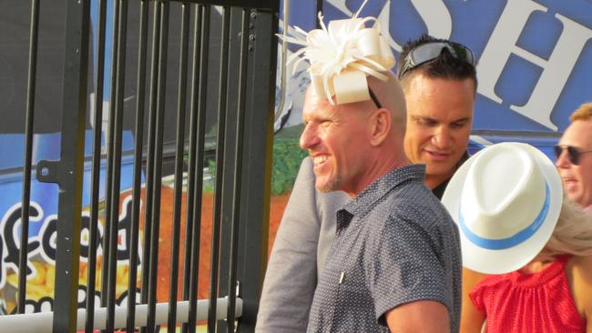 A man wearing a fascinator leaves the Gold Coast Turf Club.