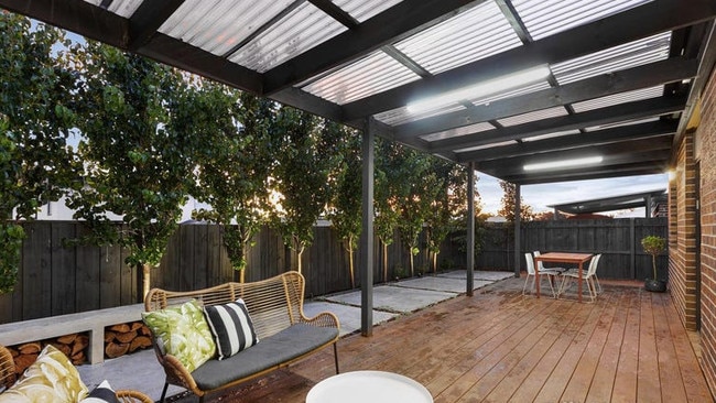 The outdoor deck is surrounded by fences and trees, creating a sense of privacy.