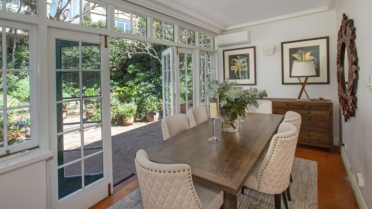 The dining room opens through glass doors to the back yard.