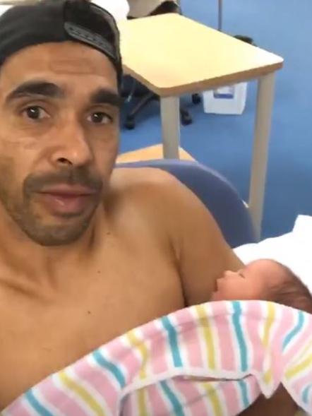 Eddie Betts with one of his twin daughters after watching their birth via FaceTime. Picture: Instagram