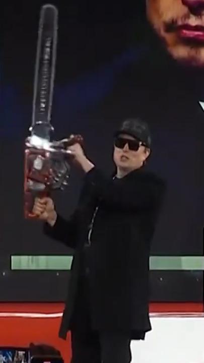 Elon Musk brandishes chainsaw on stage