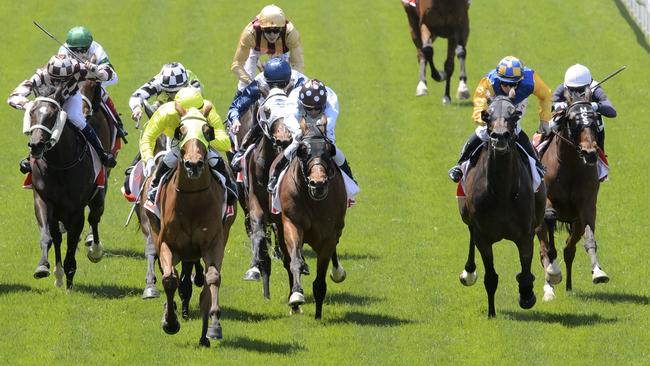 Sin to Win, ridden by Luke Currie (yellow cap) storms home to win The Maccas Rub. Picture: Jay Town