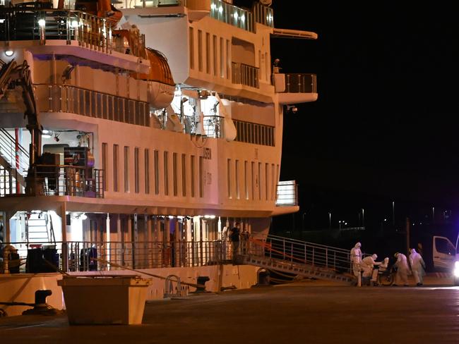 Passengers of the COVID-19 coronavirus-stricken Australian liner Greg Mortimer disembark in personal protective equipment from the cruise ship. Picture: AFP