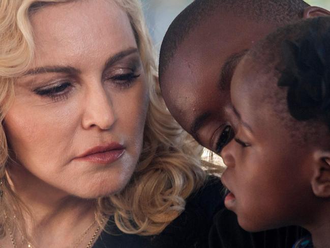 US popstar Madonna, her son David Banda (C) and one of her newly adopted daughters attend the opening ceremony of the Mercy James Children's Hospital named after her at Queen Elizabeth Central Hospital in Blantyre, Malawi on July 11, 2017. Madonna on July 11 took her four adopted Malawian children back to their home country for the opening of a paediatric hospital wing that her charity has built. / AFP PHOTO / AMOS GUMULIRA