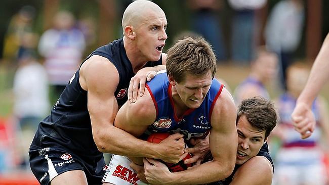 South Adelaide’s Jake Veade, left, tackles Central District’s Trent Goodrem with help fro