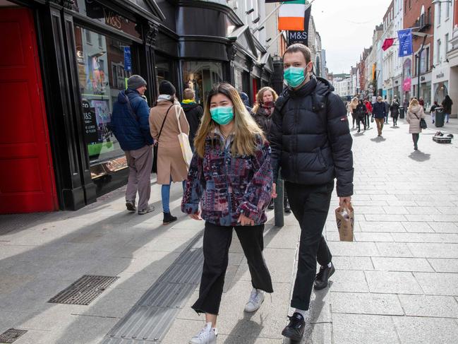 A couple walks through Dublin’s busy Grafton shopping area. Ireland announced the closure of all schools and colleges. Picture: AFP