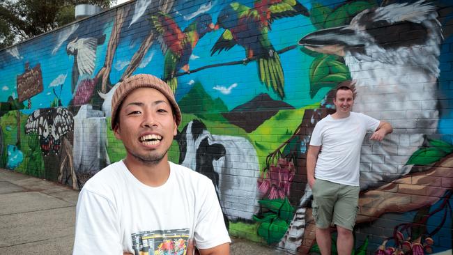 Artist Satoshi Sasayama and Josh Allen with the mural in the Diamond Creek IGA carpark.