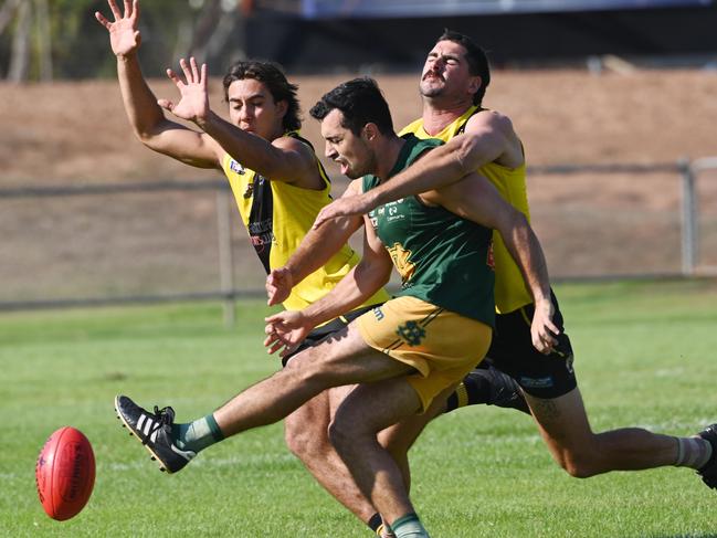 St Mary’s Nate Paredes is tackled as he kicks the ball through against Nightcliff. Picture: Julianne Osborne