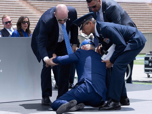 TOPSHOT - US President Joe Biden is helped up after falling during the graduation ceremony at the United States Air Force Academy, just north of Colorado Springs in El Paso County, Colorado, on June 1, 2023. (Photo by Brendan Smialowski / AFP)