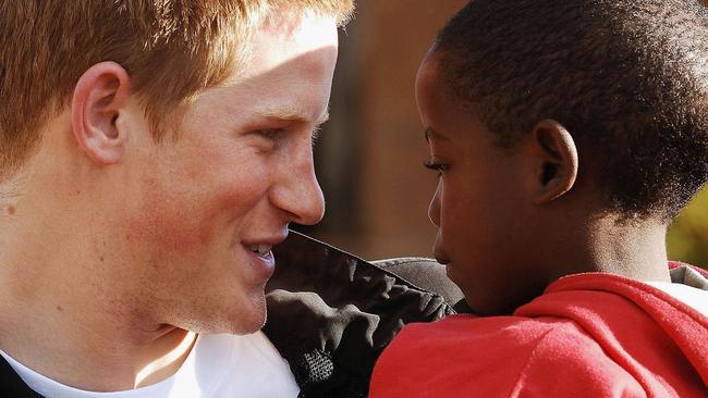 LESOTHO - APRIL 24: (EMBARGOED: NOT FOR PUBLICATION BEFORE 0001 FRIDAY APRIL 28, 2006.) Prince Harry holds his old friend, Mutsu Potsane, in the grounds of the Mants'ase children's home, while on a return visit to Lesotho on April 24, 2006 in southern Africa. The Prince was in the country to launch his new charity called 'Sentebale', which means 'Forget me not' in memory of his mother Princess Diana. (Photo by Pool/Anwar Hussein Collection/Getty Images)