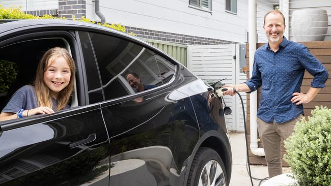 Jonathan Prendergast with his daughter Olivia, charging his electric car. Picture: Ted Lamb