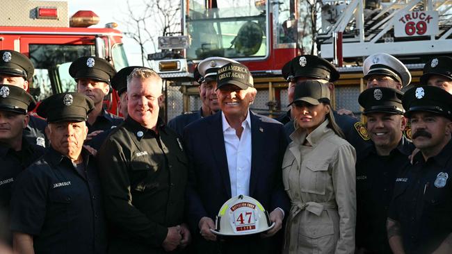 The President and First Lady Melania Trump pose with a helmet reading ‘Batallion Chief 47’ donated by firefighters from Station 69 as they tour areas in Pacific Palisades. Picture: Mandel Ngan / AFP