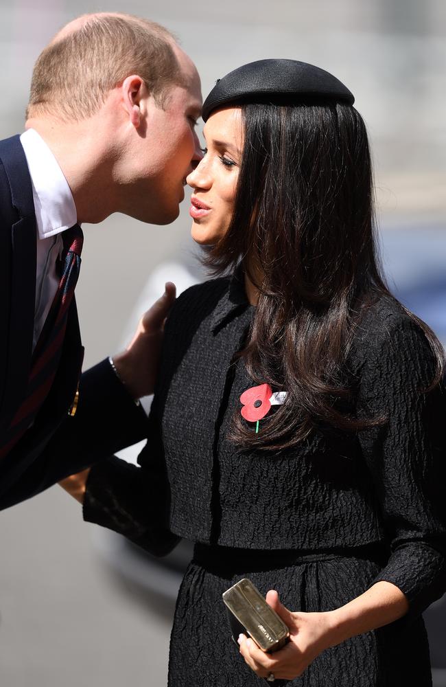 The Duke of Cambridge, Prince Harry and Meghan Markle lean in for a kiss. Picture: James Whatling / MEGA