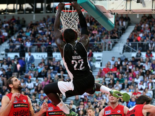 Majok Majok dunks over four Wildcat players. Picture: Mark Dadswell