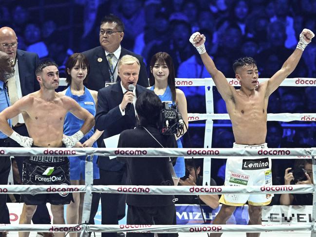 Japan's Yoshiki Takei (R) celebrates his upset decision victory over Australia's Jason Moloney (front L) at the end of their WBO bantamwight title boxing match at the Tokyo Dome in Tokyo on May 6, 2024. (Photo by Philip FONG / AFP)