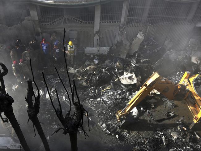 Volunteers look for survivors of a plane, crashed in residential area of Karachi, Pakistan, May 22, 2020. An aviation official says a passenger plane belonging to state-run Pakistan International Airlines carrying more than 100 passengers and crew has crashed near the southern port city of Karachi. (AP Photo/Fareed Khan)