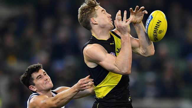 Tom Lynch flies for a mark in front of Geelong’s Mark O’Connor on Friday night. Picture: Picture: Quinn Rooney/Getty Images.