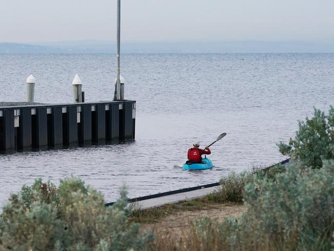 A kayaker is seen paddling at Mordialloc beach at sunrise in Melbourne, Friday, April 3, 2020. Victoria's first weekend since harsher social distancing laws were implemented will start with a ban on all but the most basic outdoor activities. (AAP Image/Michael Dodge) NO ARCHIVING