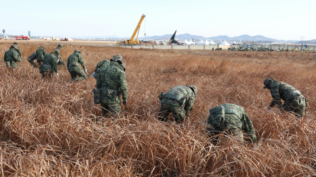 Soldiers search at the site of the Jeju Air passenger plane crash at Muan International Airport