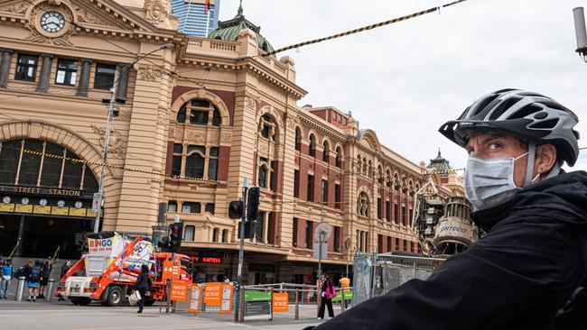 A cyclist wears a mask outside Flinders Street station on March 23, 2020.